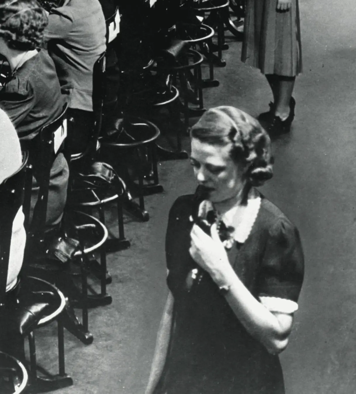 Una operadora de los años 40 habla por el auricular; detrás, otras operadoras trabajan sentadas frente al tablero.